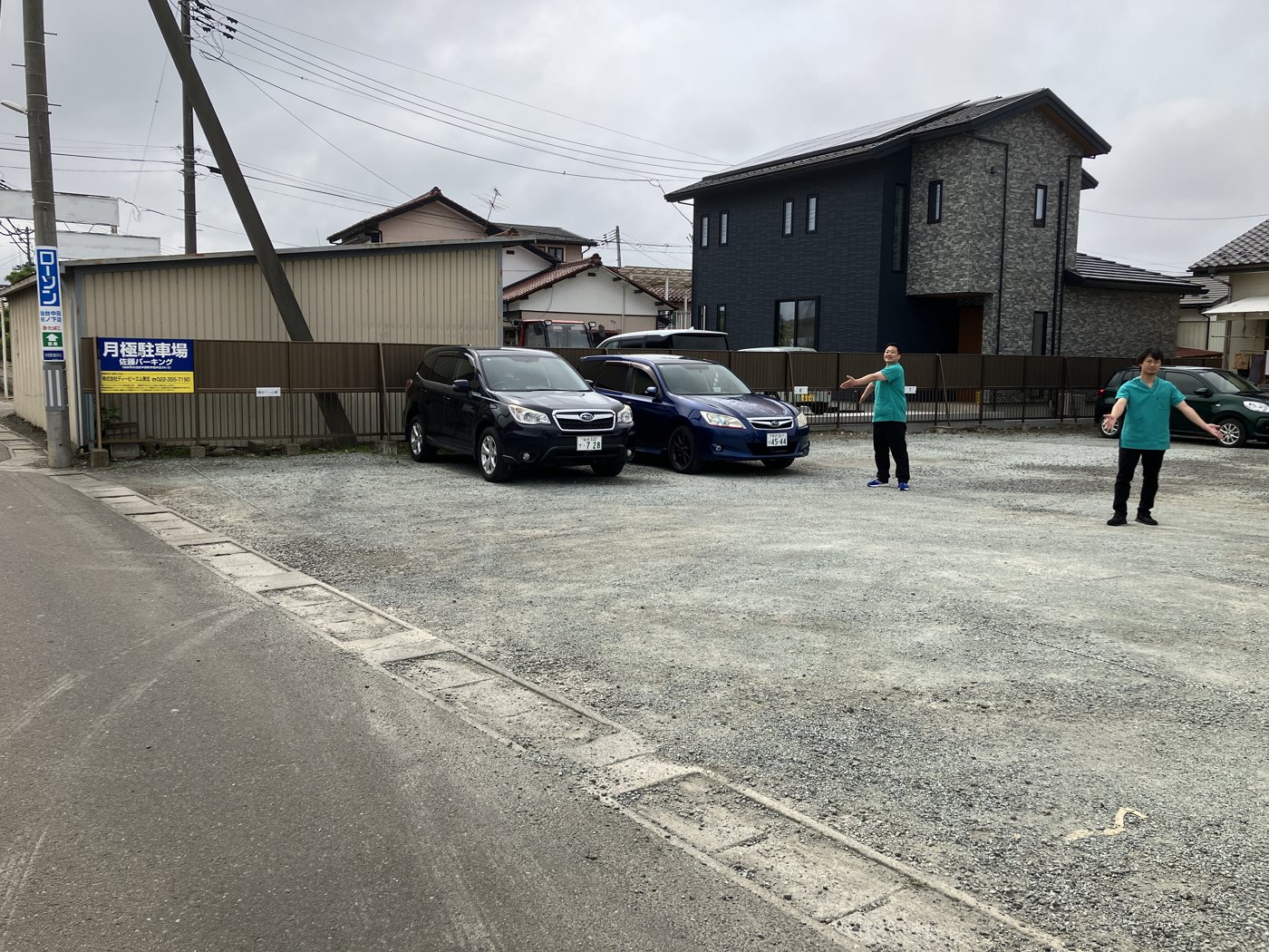 道路から見た砂利の駐車場の入口