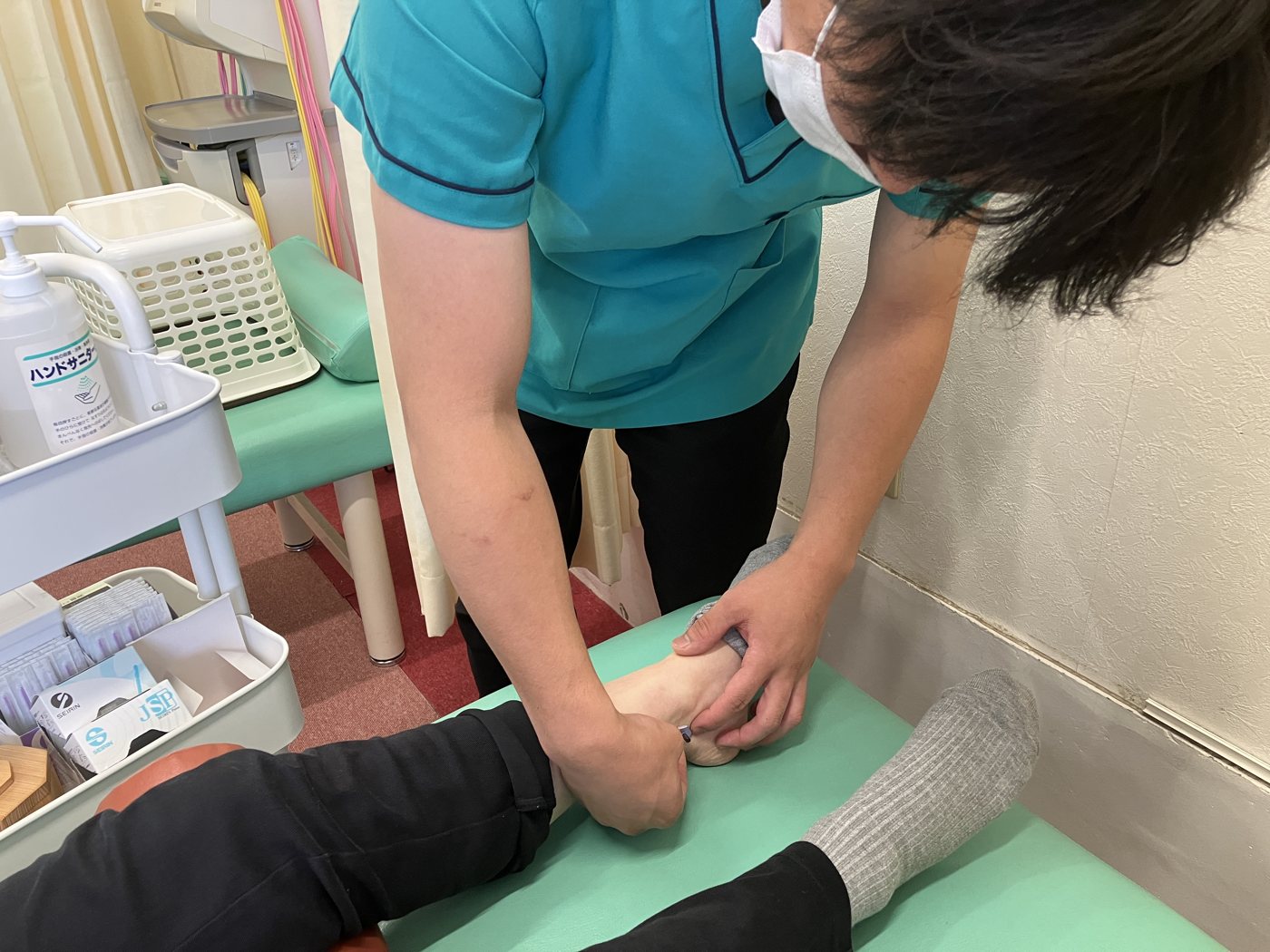 足首まわりの状態を確認している様子
